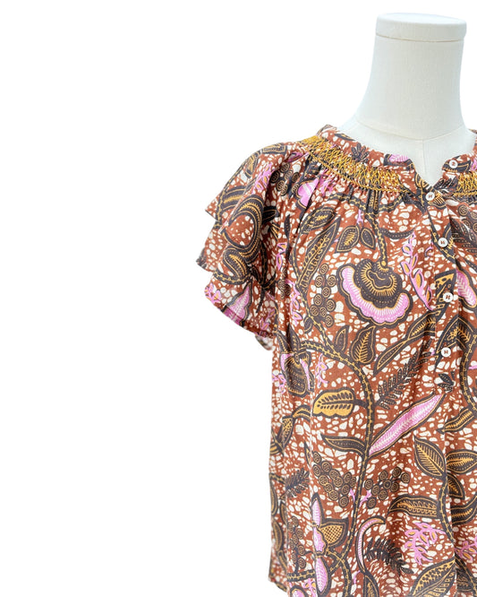 Xirena floral patterned blouse on a mannequin against a white background