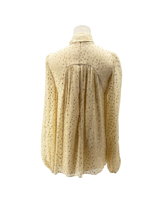 Beige polka dot blouse on a mannequin against a white background