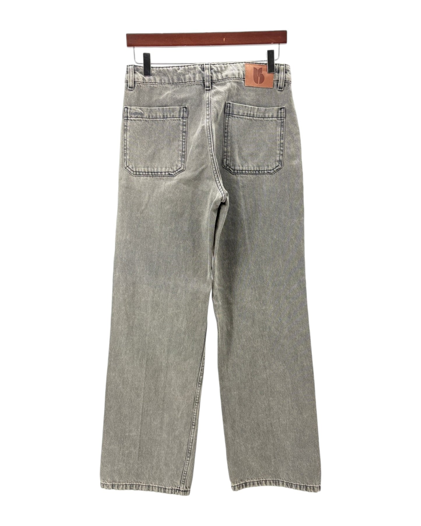 Gray jeans on a hanger against a white background