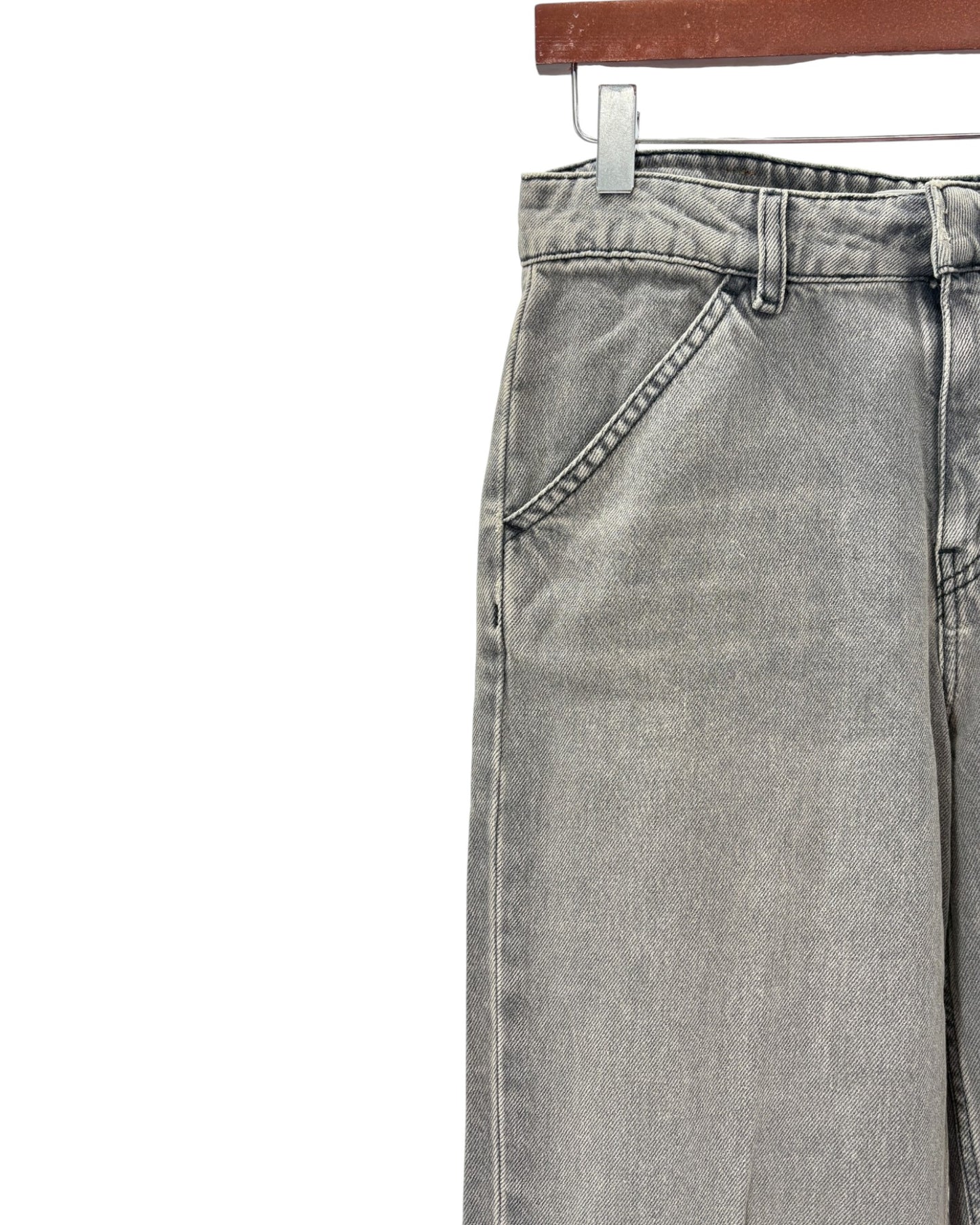 Gray jeans on a hanger against a white background