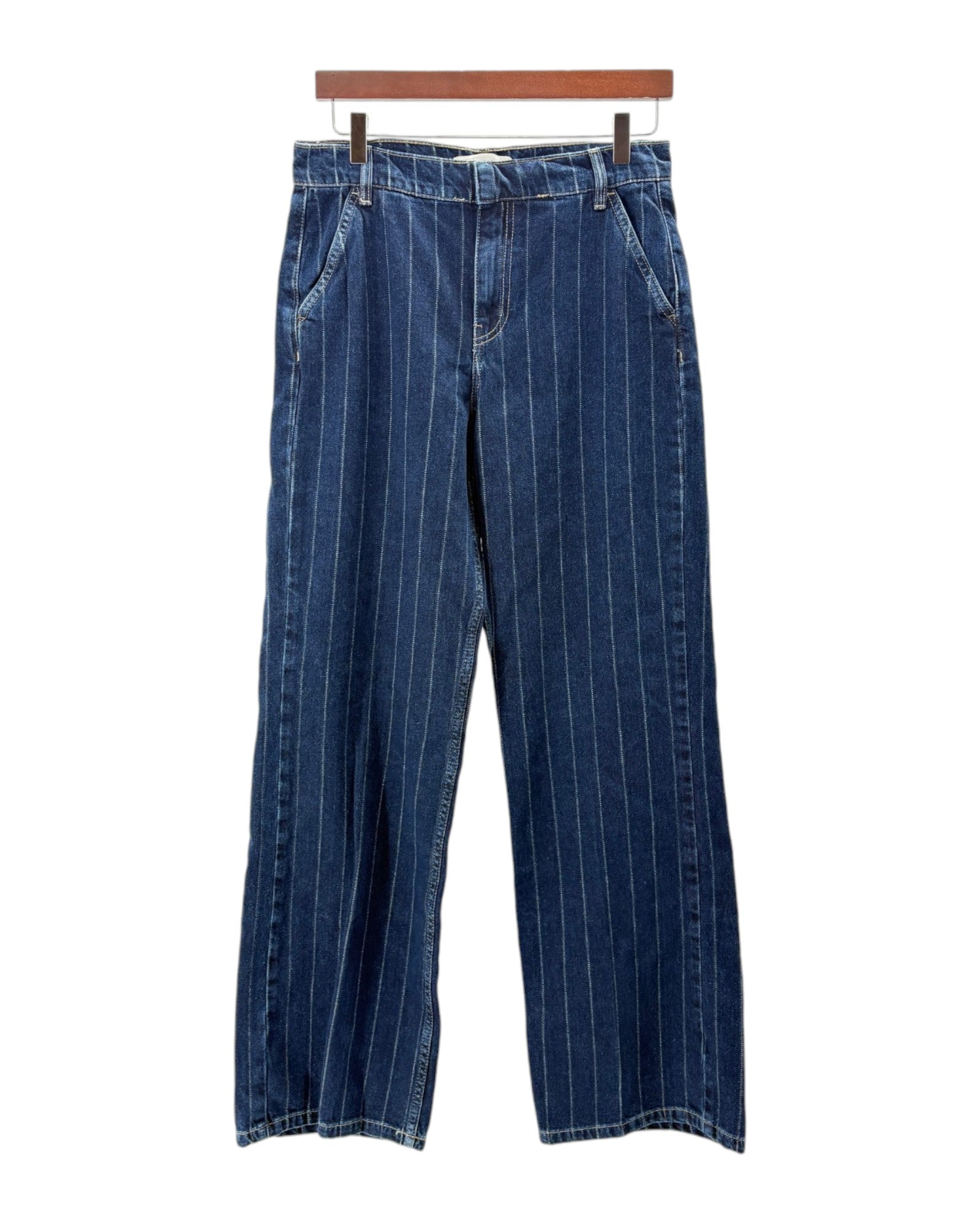 Blue denim pants on a hanger against a white background