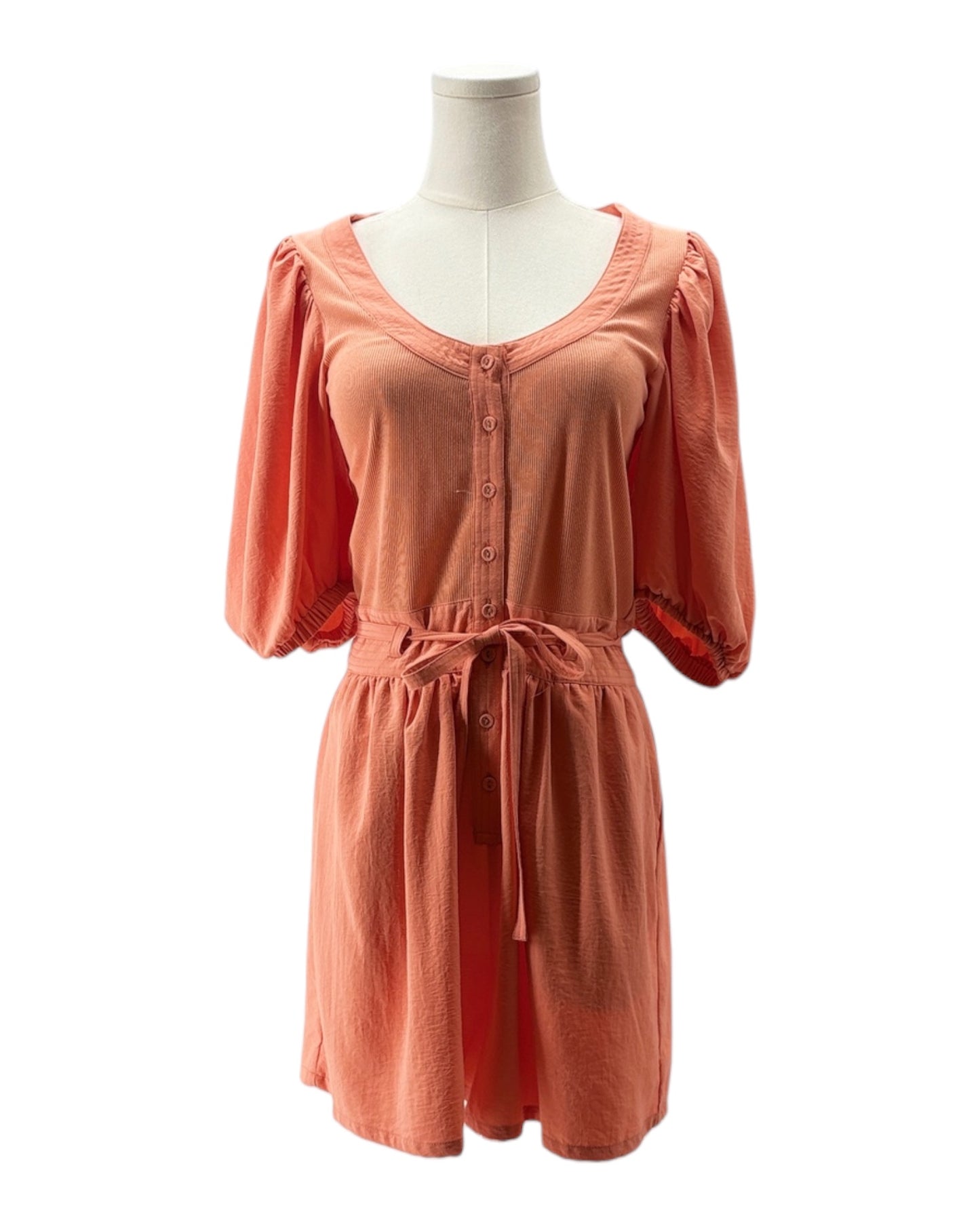 Coral romper on a mannequin against a white background