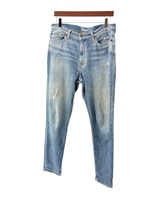 Pair of blue jeans on a hanger against a white background