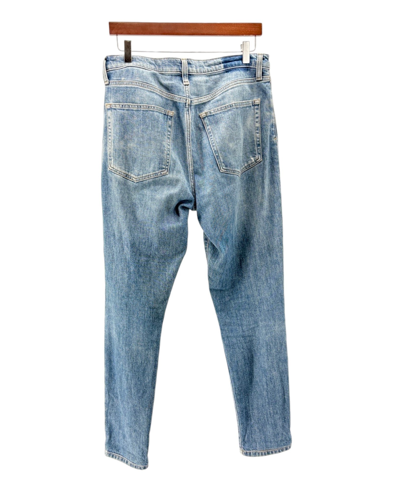Blue jeans on a hanger against a white background